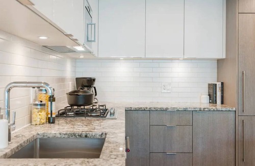 South Lake Union House | Level Seattle- Executive Two Bedroom Suite with separate office space, bedroom with king bed, full kitchen, living & dining area, private balcony, in-suite laundry, modern bathroom with Malin + Goetz amenities.