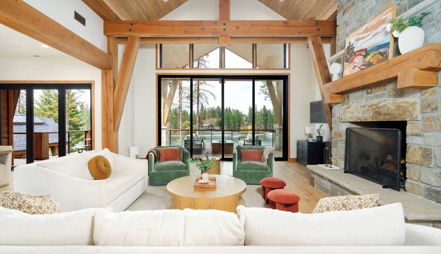 A 5,200 sq ft home on the Spokane River, twelve minutes to Coeur d'Alene and ten to downtown Post Falls. Six bedrooms and five full baths across the main house and guest house, plus a private sandy beach, a dock, and a river-view hot tub.